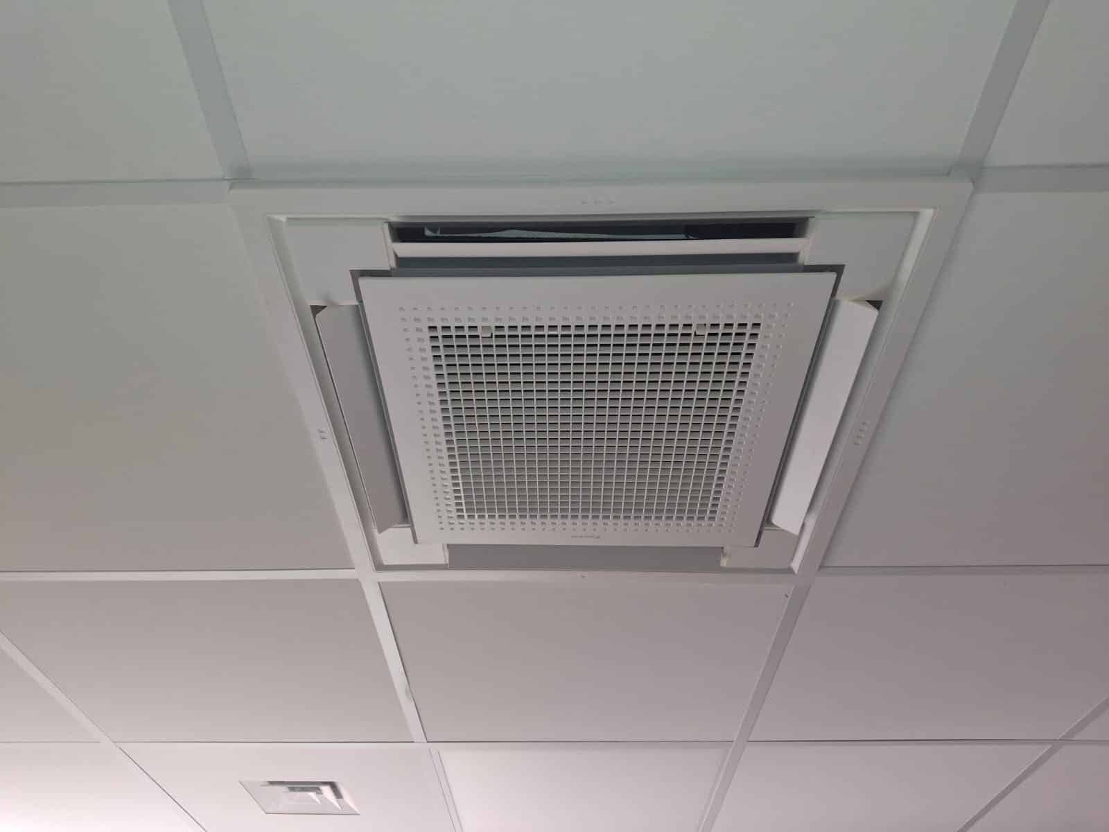 Cassette de climatisation encastrée dans un faux plafond de bureau