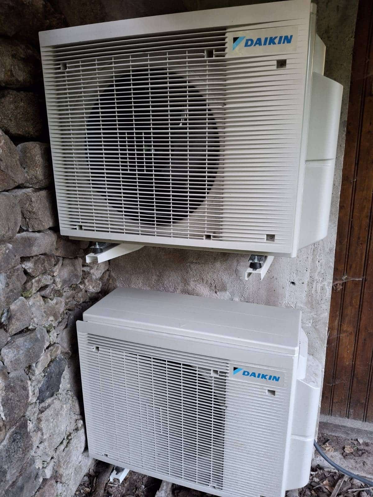 Deux groupes extérieurs de climatisation Daikin fixés sur un mur en pierre