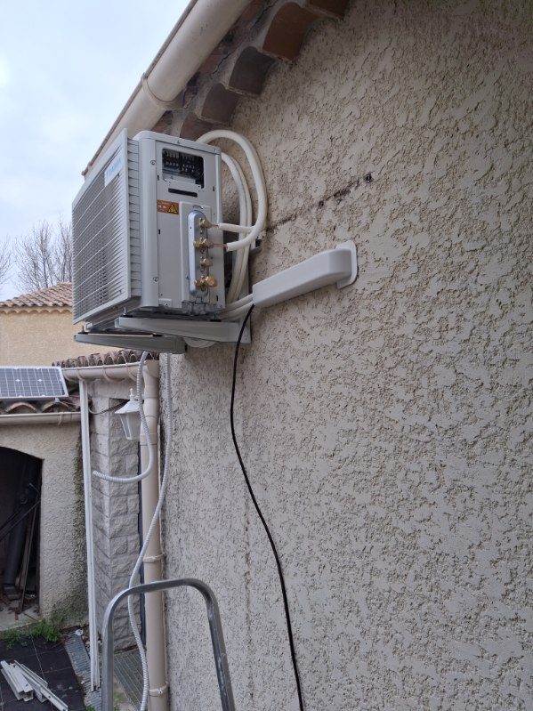 Groupe extérieur de climatisation fixé en façade avec ses liaisons frigorifiques