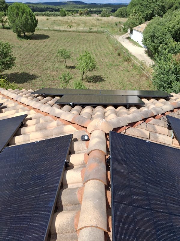 Panneaux photovoltaïques répartis sur deux pans de toiture, vue sur la campagne